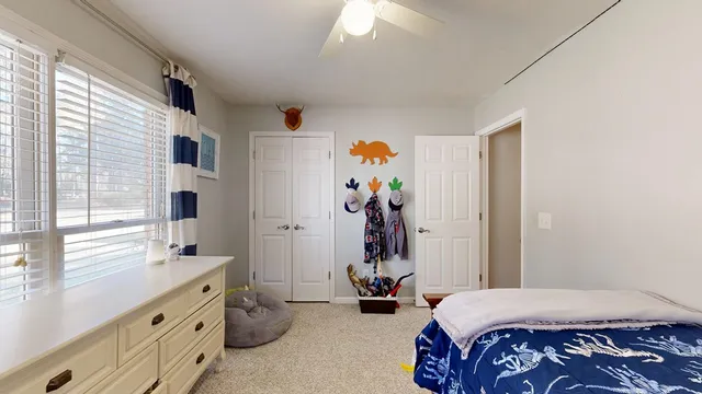 a bedroom with a bed and a large window