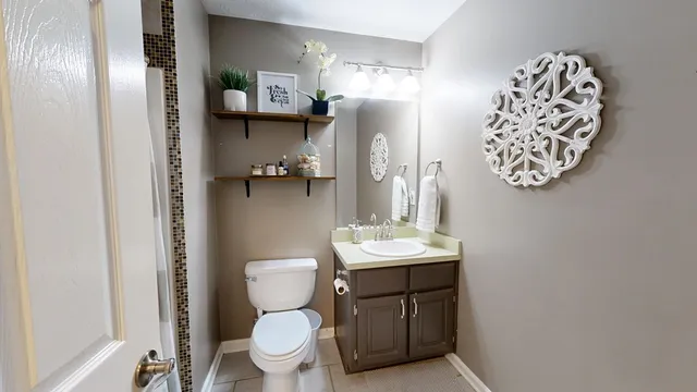 a bathroom with a toilet sink and mirror