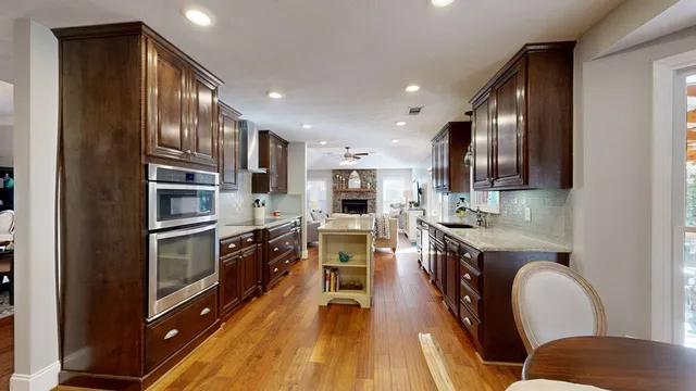 a kitchen with counter top space stainless steel appliances and wooden floor