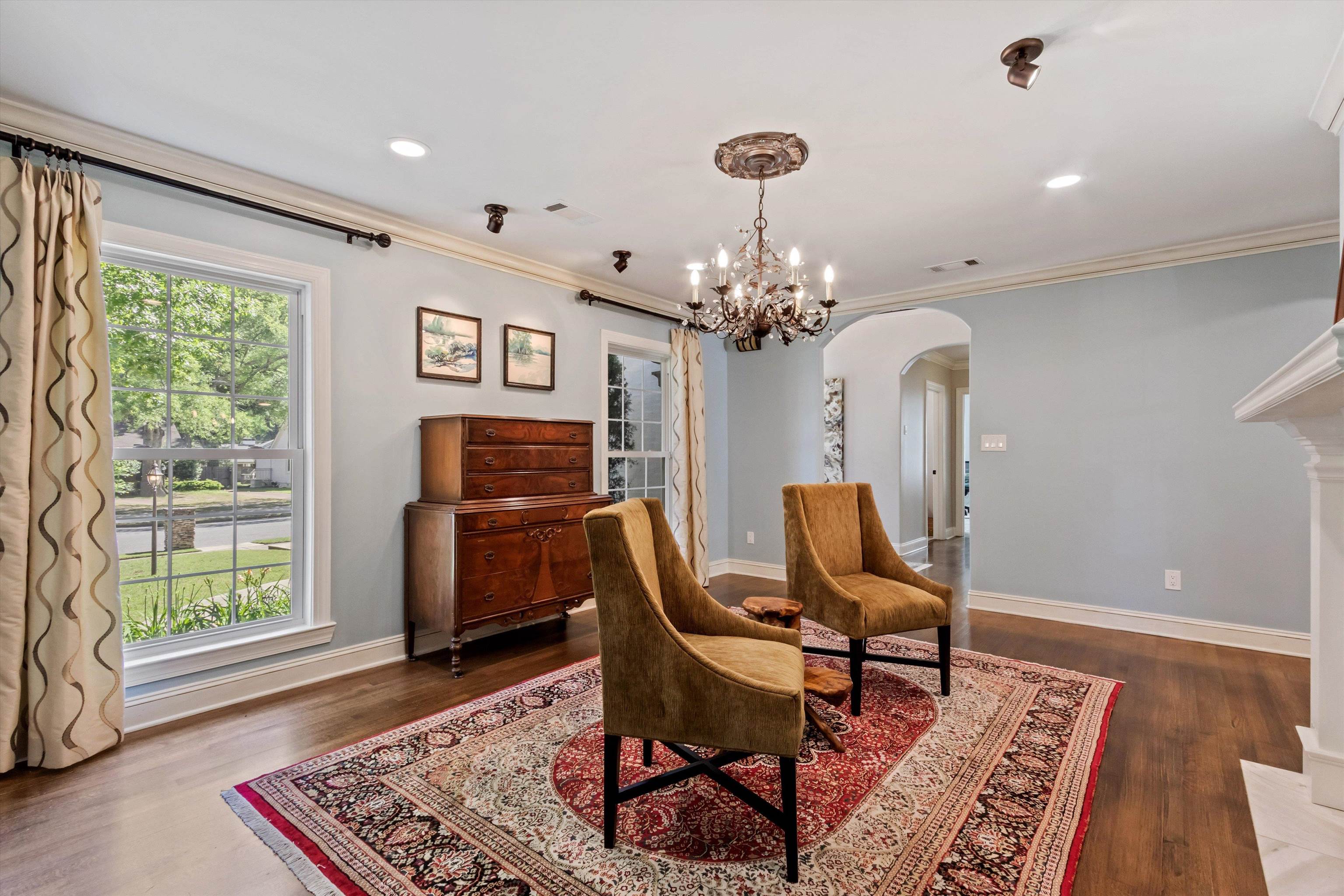 5302 South Angela Road Memphis, TN 38120 - Photo 9 of 40 Living space featuring wood-finish flooring, a white mantel, an arched entry, and crown molding