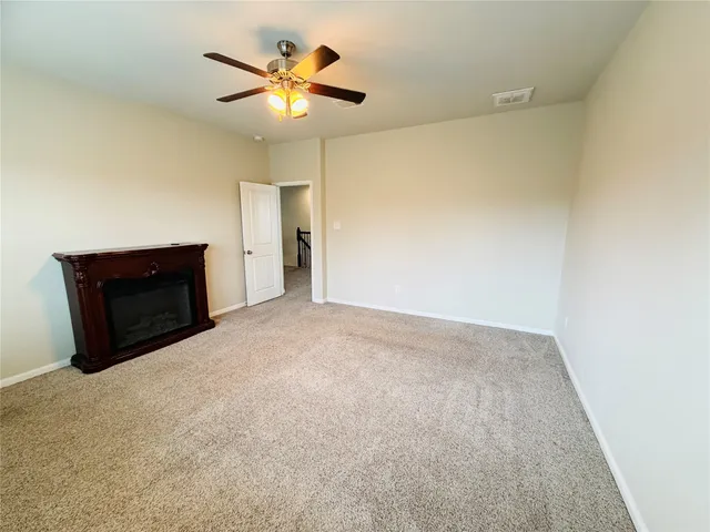 a view of an empty room with a chandelier fan