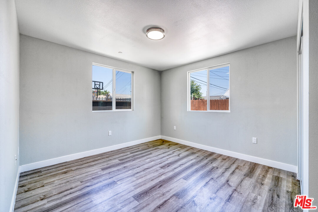 1947 East 114th Street, Unit 1947 1/2 Los Angeles, CA 90059 - Photo 11 of 16 an empty room with wooden floor and windows