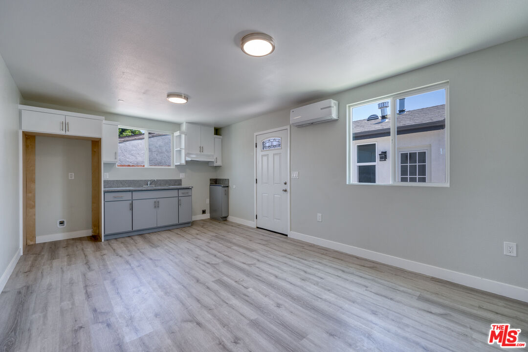 1947 East 114th Street, Unit 1947 1/2 Los Angeles, CA 90059 - Photo 5 of 16 a view of a kitchen with a fridge and wooden floor