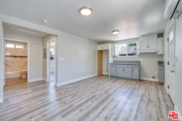 a view of a kitchen with a sink and dishwasher with wooden floor