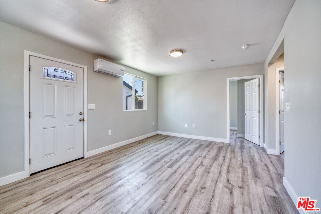 1947 East 114th Street, Unit 1947 1/2 Los Angeles, CA 90059 - Photo 7 of 16 a view of an empty room with wooden floor and a window