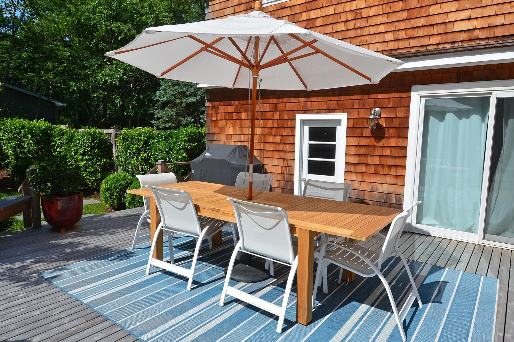 475 7 Ponds Towd Road Water Mill, NY 11976 - Photo 9 of 18 a view of a patio with table and chairs under an umbrella