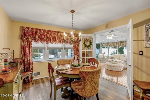 a dining room with furniture a chandelier and wooden floor