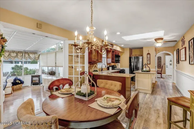 a view of a dining room and livingroom with furniture wooden floor and a chandelier