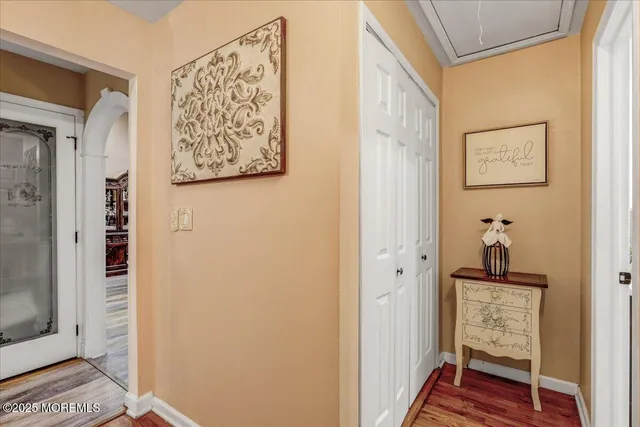 a hallway with wooden floor and a bookshelf