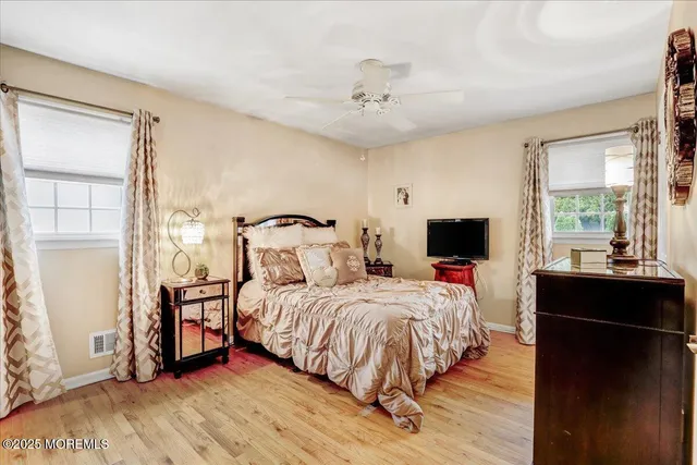 a bedroom with a bed and wooden floor