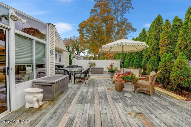 a view of a roof deck with table and chairs under an umbrella with wooden floor