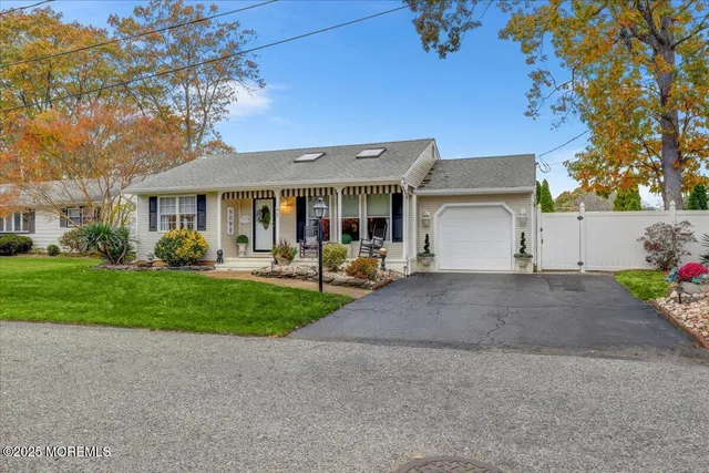 a front view of a house with garden and trees