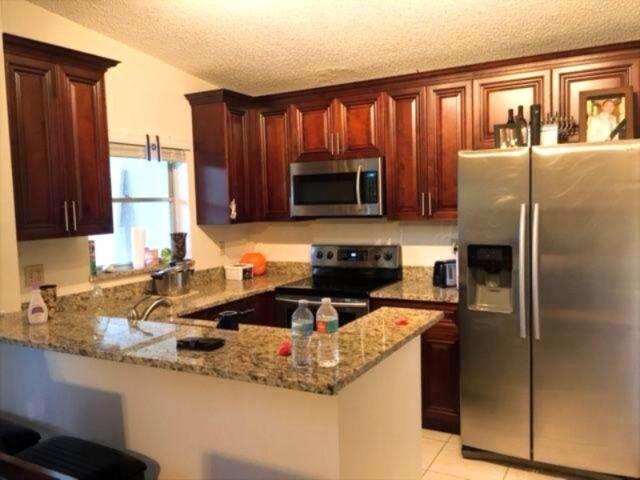 11750 Timbers Way Boca Raton, FL 33428 - Photo 5 of 25 a kitchen with granite countertop a refrigerator stove and microwave