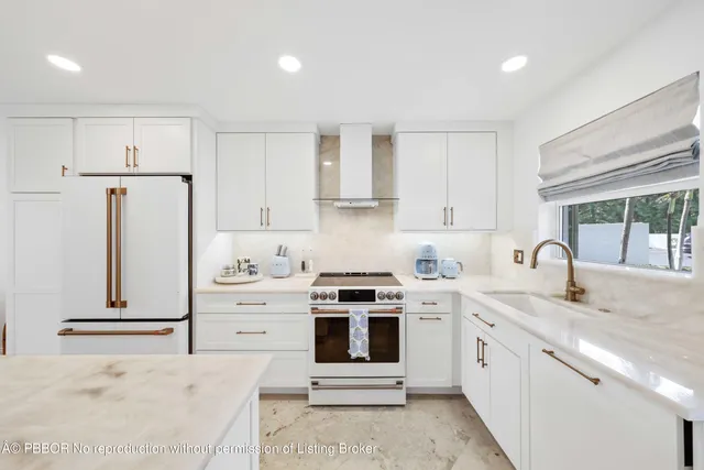 a kitchen with stainless steel appliances granite countertop a stove a sink and a refrigerator