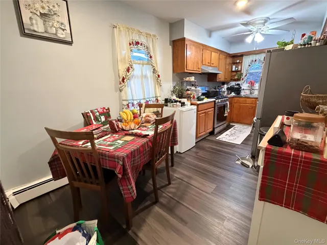 a kitchen with stainless steel appliances a stove a refrigerator a sink dishwasher and a dining table with wooden floor