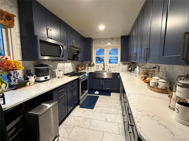 a kitchen with counter top space a sink stainless steel appliances and cabinets