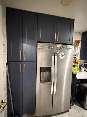 a metallic refrigerator freezer sitting in a kitchen