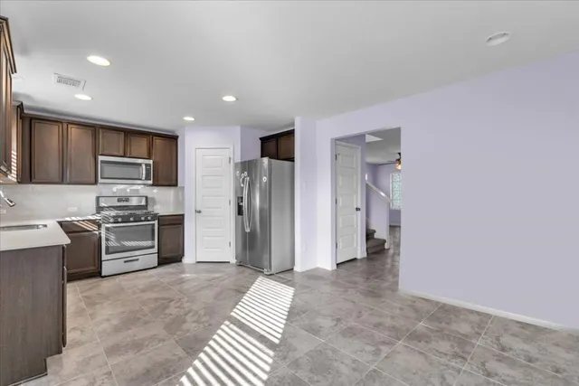 a kitchen with stainless steel appliances granite countertop a refrigerator stove and sink