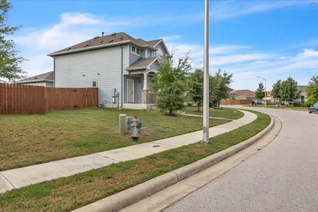 a view of a house with a yard and fence
