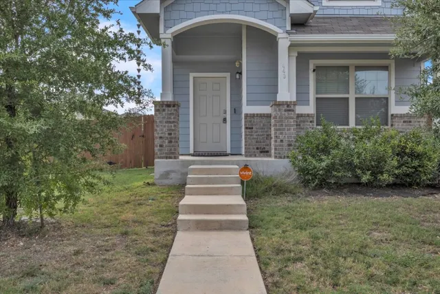a front view of a house with a yard and trees