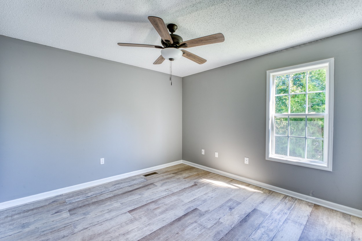 1464 Little Dry Creek Road Pulaski, TN 38478 - Photo 19 of 26 an empty room with wooden floor fan and windows