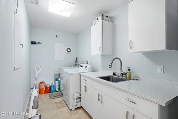 a kitchen with white cabinets and sink