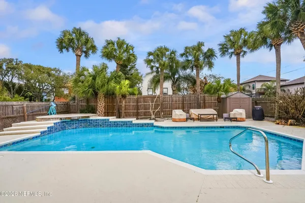 a view of swimming pool with a table and chair