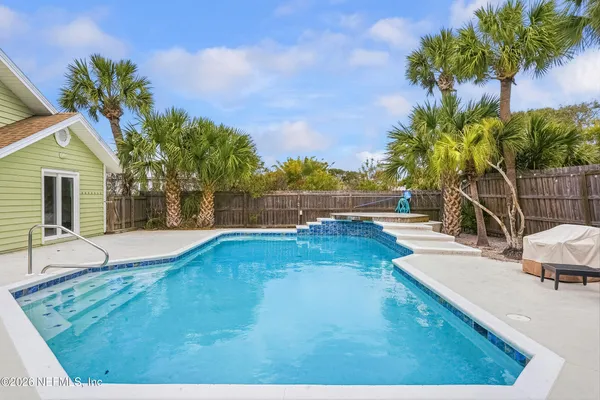 a view of a backyard with plants and swimming pool