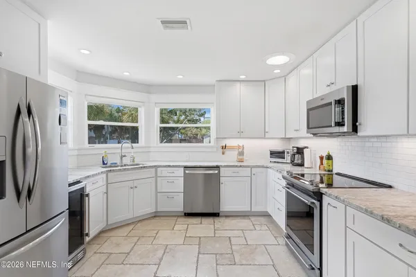 a kitchen with a sink a window and stainless steel appliances