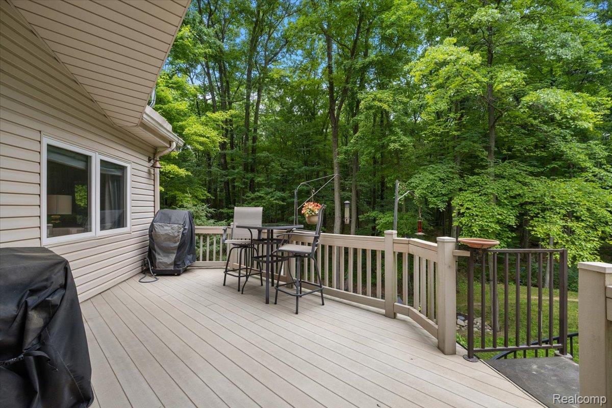 4219 Gardner Road Metamora, MI 48455 - Photo 62 of 84 Expansive outdoor deck with composite decking and light-colored railing, offering a serene backdrop of mature trees