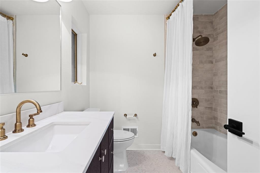 922 Barton Woods Road Northeast Atlanta, GA 30307 - Photo 56 of 96 a bathroom with a sink and mirror with toilet