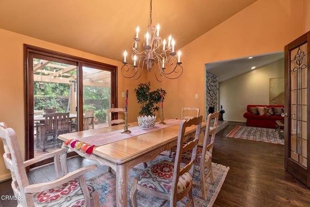 a view of a dining room with furniture a chandelier and wooden floor