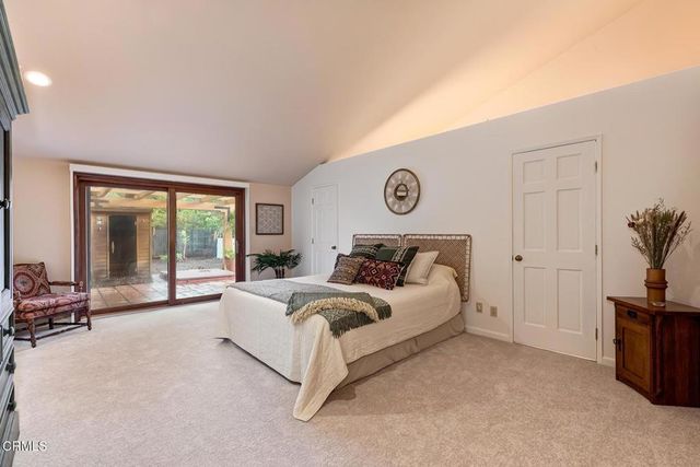 a bedroom with a bed and a chair with the outer view