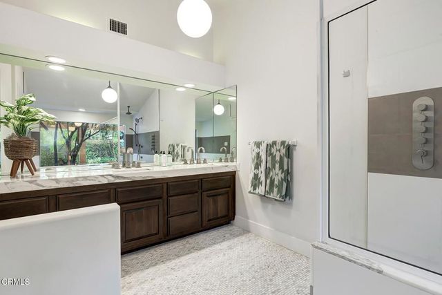 a spacious bathroom with a granite countertop sink a toilet a mirror and vanity
