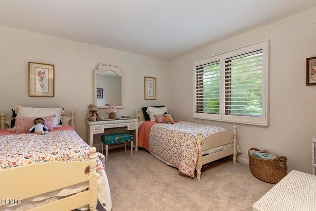 a bedroom with two beds and a large window