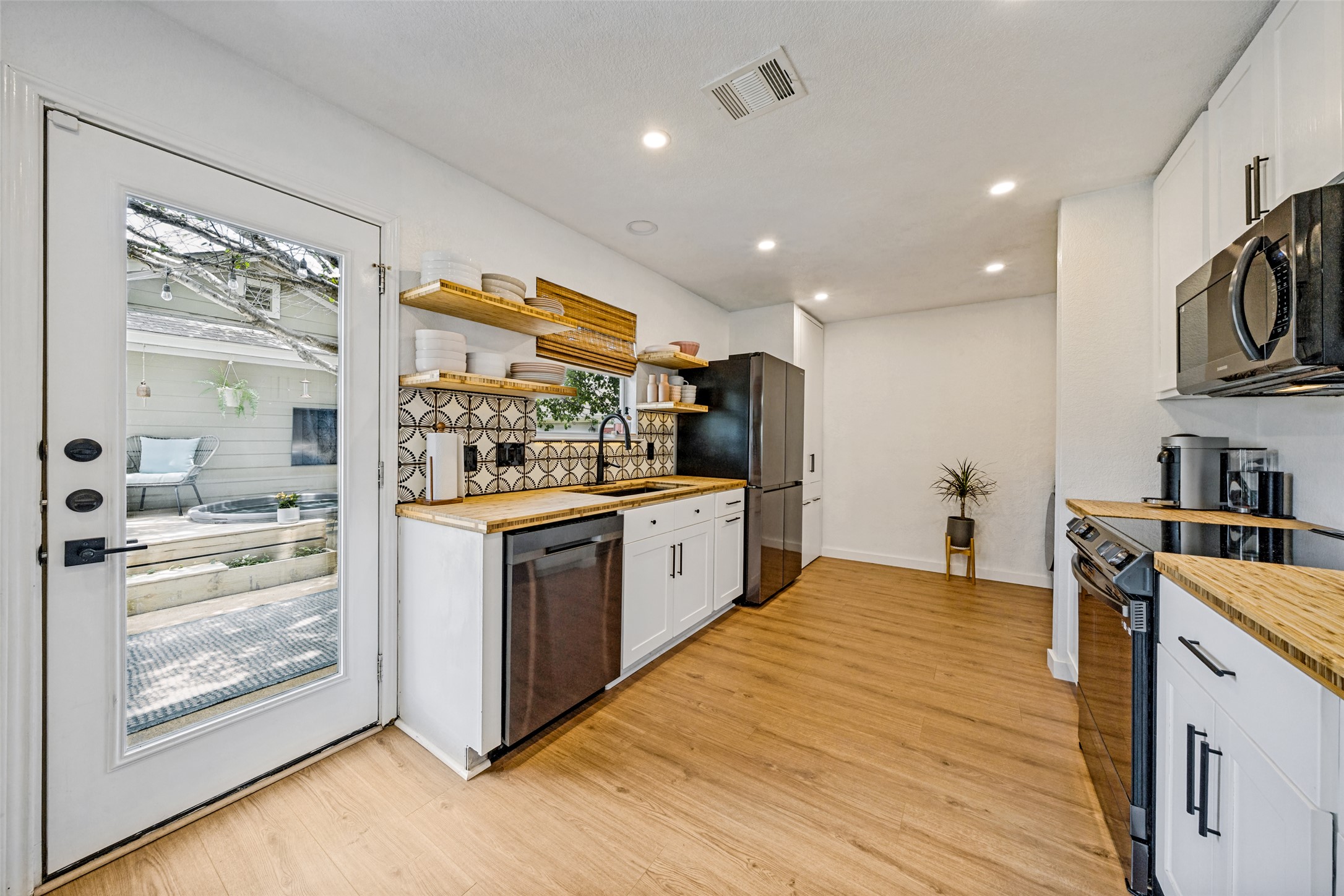 9205 Rowlands Sayle Road Austin, TX 78744 - Photo 8 of 25 A well-equipped kitchen features wooden countertops and a view to a secluded outdoor space.