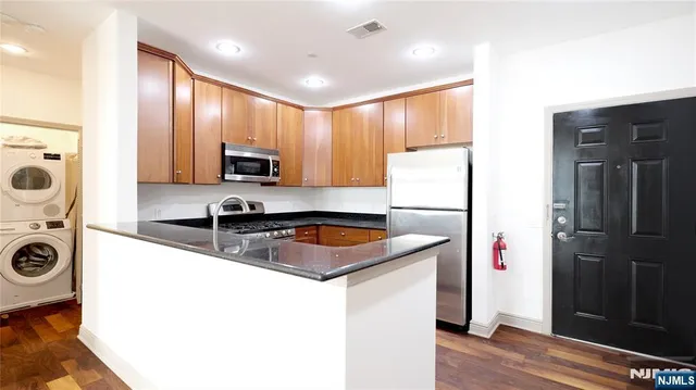 a kitchen that has a sink a refrigerator and cabinets