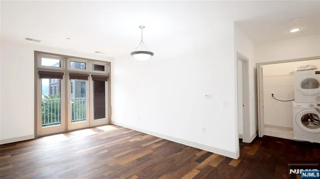 an empty room with wooden floor and mirror