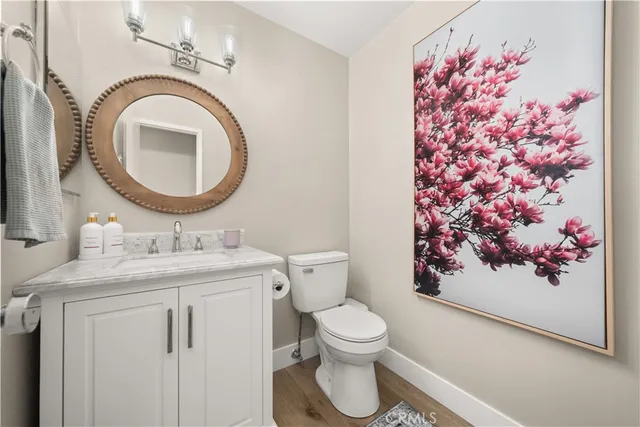 a bathroom with a toilet sink vanity and mirror