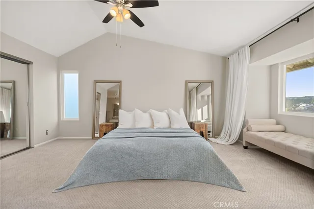 a spacious bedroom with a bed a couch and a chandelier