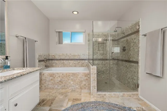 a bathroom with a granite countertop bathtub shower sink and mirror