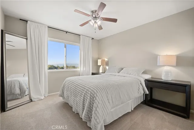 a bedroom with a bed and a ceiling fan