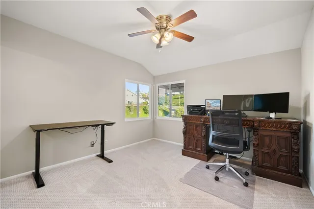 a view of a workspace with furniture and a window