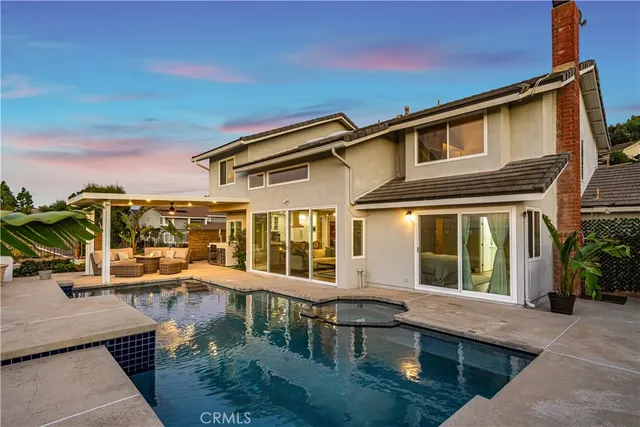 a view of a house with pool and chairs