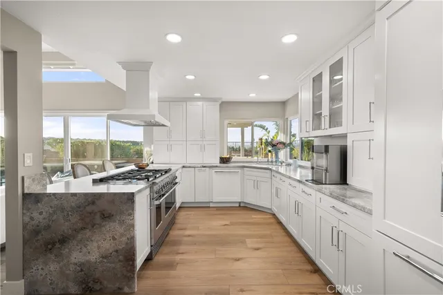 a large kitchen with a large counter top and stainless steel appliances
