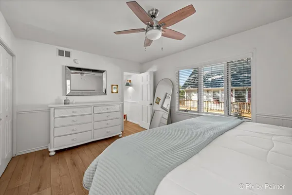 a bedroom with a bed a dresser and a large window