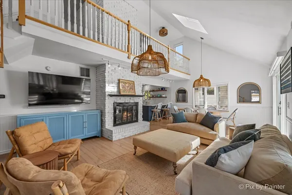 a living room with furniture kitchen view and a flat screen tv