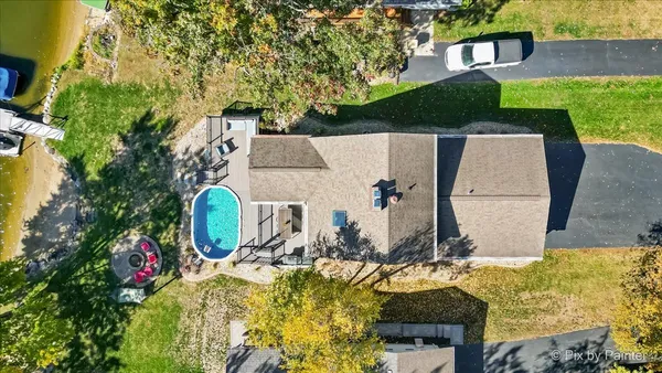 an aerial view of a house with swimming pool and large trees