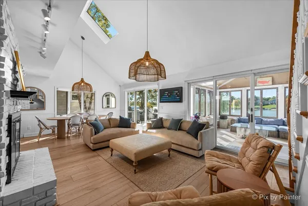 a living room with furniture a fireplace and a chandelier
