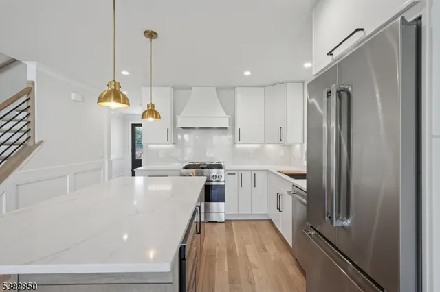 a kitchen with a refrigerator a sink and wooden floor